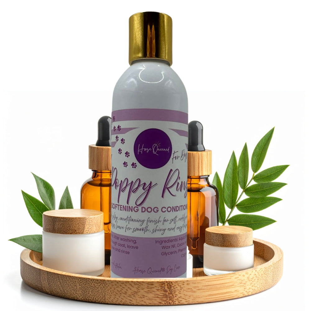 Dog care products including a bottle, dropper, and candles on a wooden tray with green leaves.